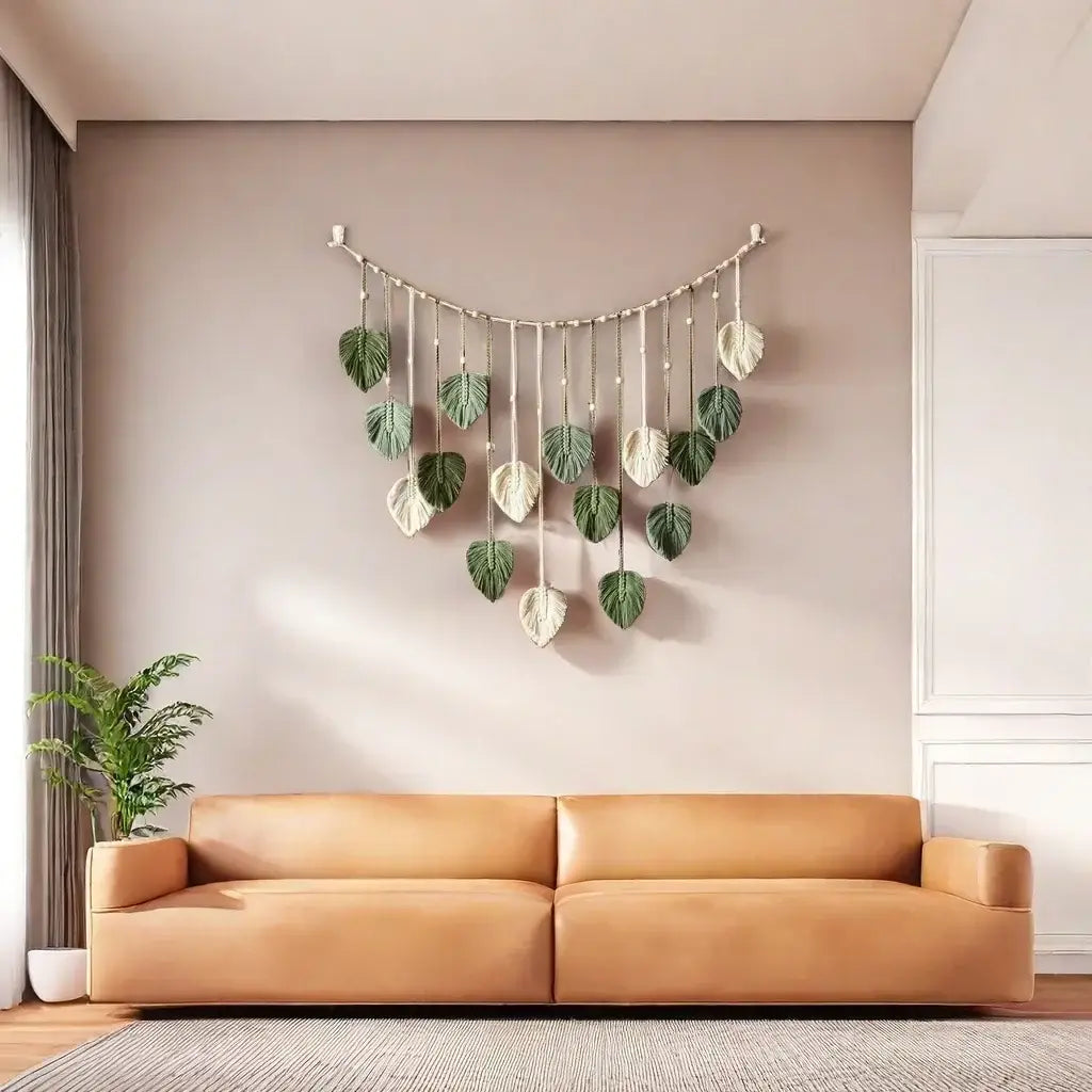 A macrame leaf wall hanging featuring green and cream-colored leaf-shaped ornaments suspended from natural fiber cord for boho decor.