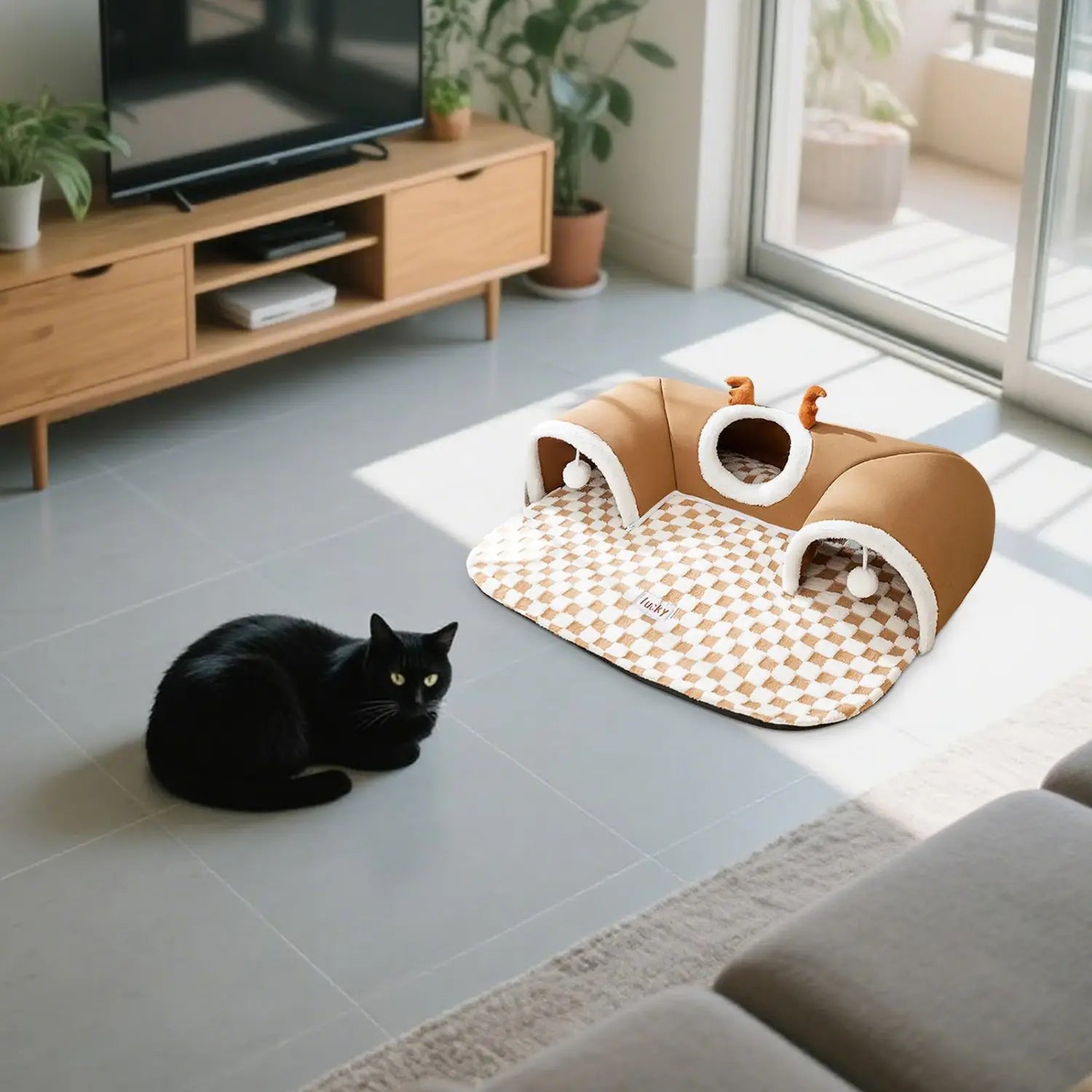 Brown and white checkered cat tunnel bed with plush rounded entrances featuring small pom-poms and antlers for a cozy cat hideaway.