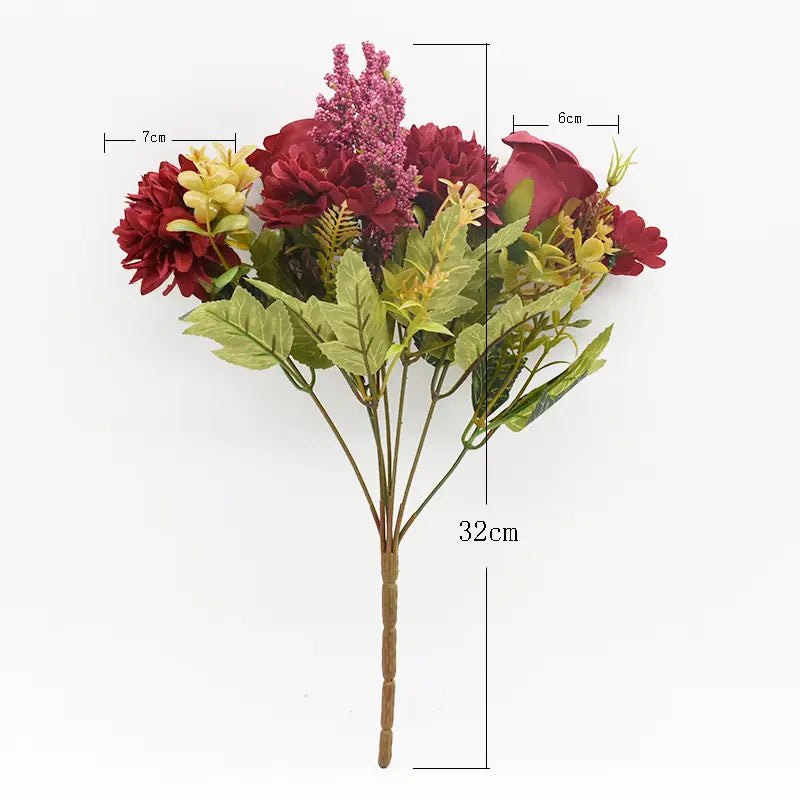 鮮やかな濃い赤と黄色の花、ならびに緑の葉物を備えた造花のバラのウェディングブーケ（合成素材で制作）。