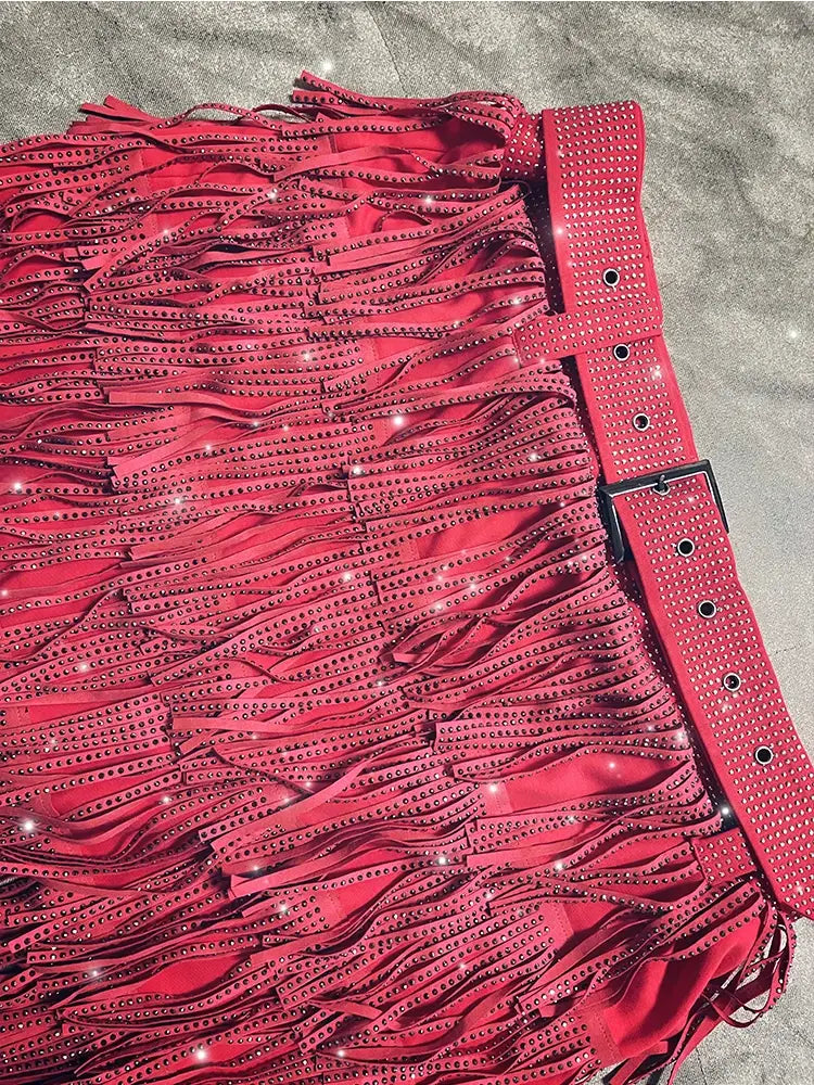 Mini-jupe taille haute rouge vif à franges en strass, ornée de rangées de strass scintillants et d’une ceinture assortie à rivets.