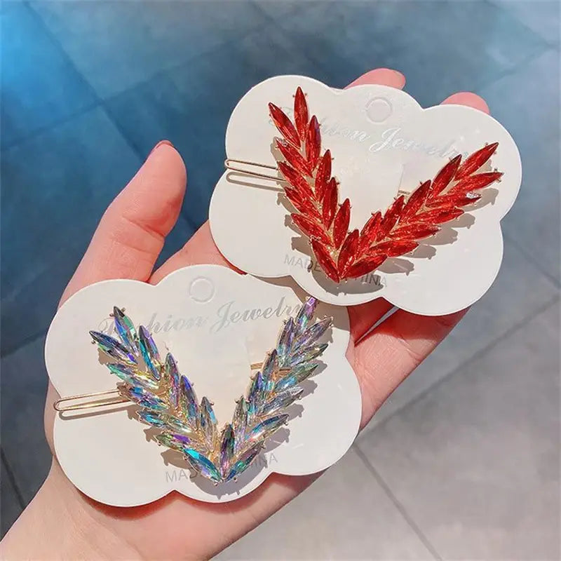 Crystal v shape hair clip set featuring red and iridescent crystal leaf designs for decorative hair styling.