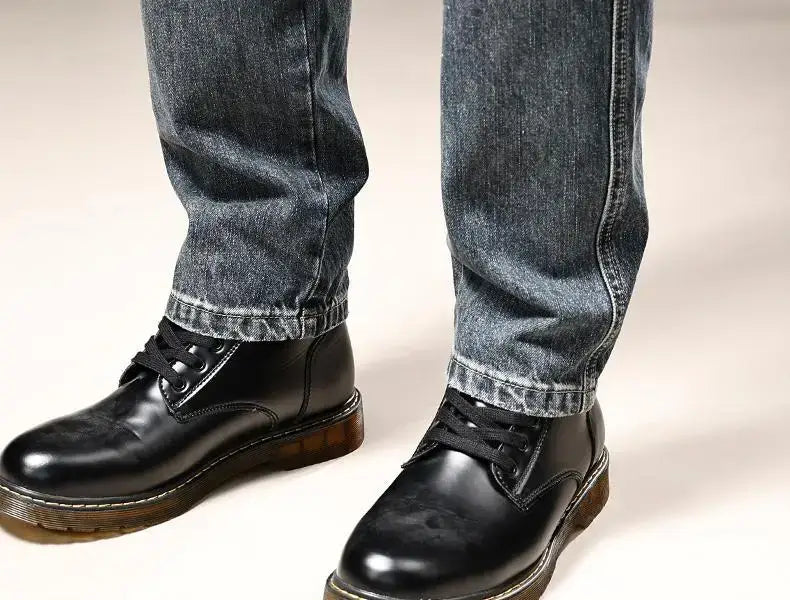 black leather lace-up boots with a brown rubber sole paired with baggy dark wash denim cargo pants y2k style