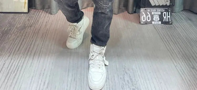 Baskets montantes blanches à lacets avec dessus texturé, associées à un pull-over en maille à empiècement contrastant pour homme, manches longues.