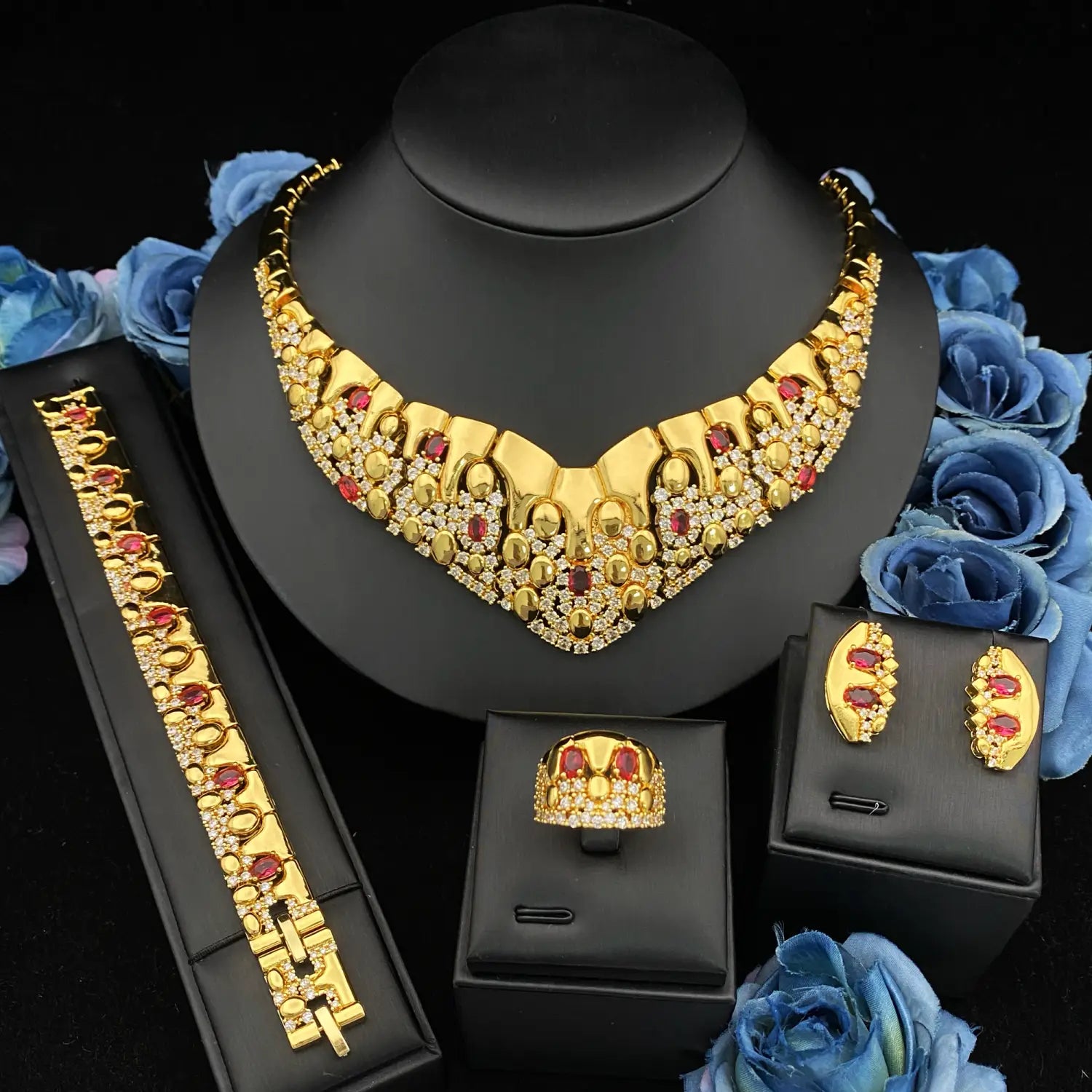 Ensemble de bijoux géométriques en zircon doré comportant un collier orné audacieux de couleur dorée avec des pierres rouges et claires.