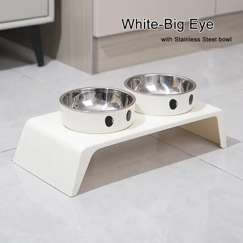 Elevated dog feeder white raised stand with two stainless steel bowls featuring black circular eye designs.
