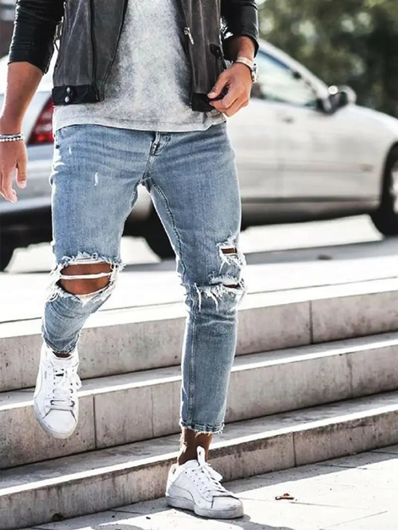 Herren-Distressed-Slim-Fit-Light-Wash-Denim-Jeans mit zerrissenen Knien und ausgefransten Säumen.