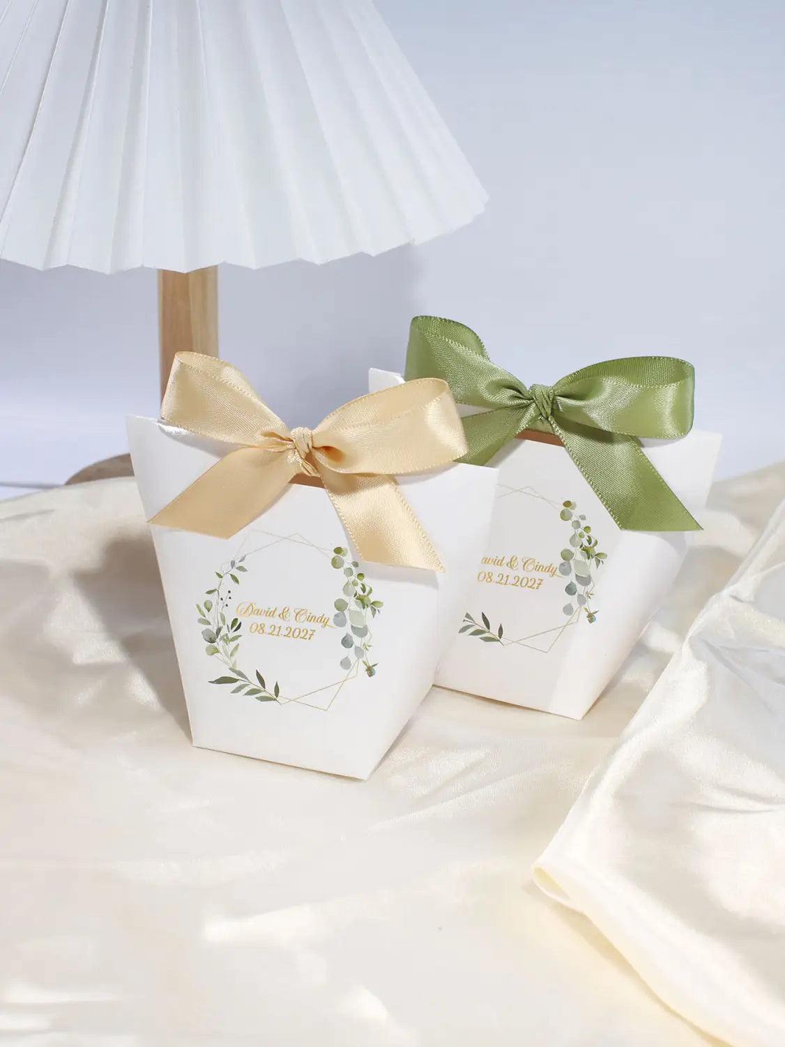 Boîtes à faveur de mariage en papier blanc personnalisables avec des couronnes de feuillage vert, des noms en feuille d’or et des nœuds en satin dans des tons or et vert olive, pour faveurs de mariage florales, 50 pièces