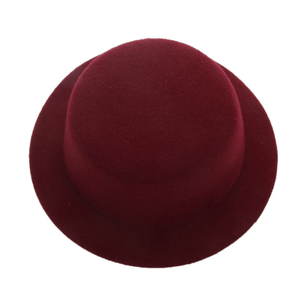 Un chapeau melon (bowler) en feutre bordeaux riche, à calotte arrondie lisse et bord légèrement incurvé, conçu comme accessoire de mode pour chapeau de poupée en peluche pour des poupées de 60 cm.