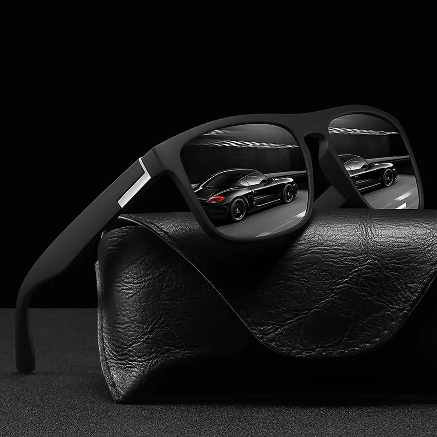 Black-framed vintage square luxury brand designer sunglasses with reflective lenses mirroring a black sports car.