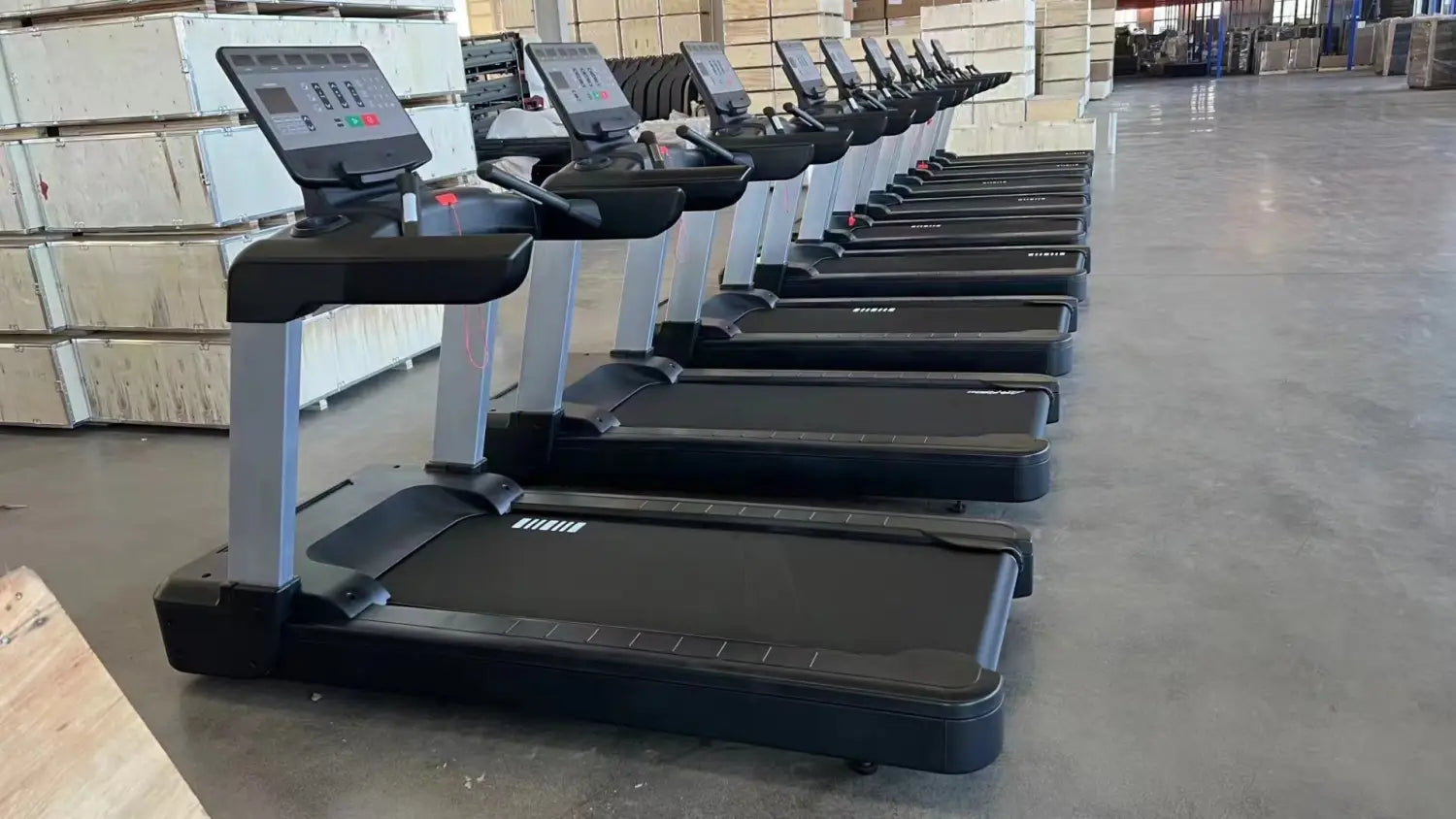 Tapis de course électrique de fitness commercial avec surface de course noire, cadre argenté et écran d’affichage numérique.