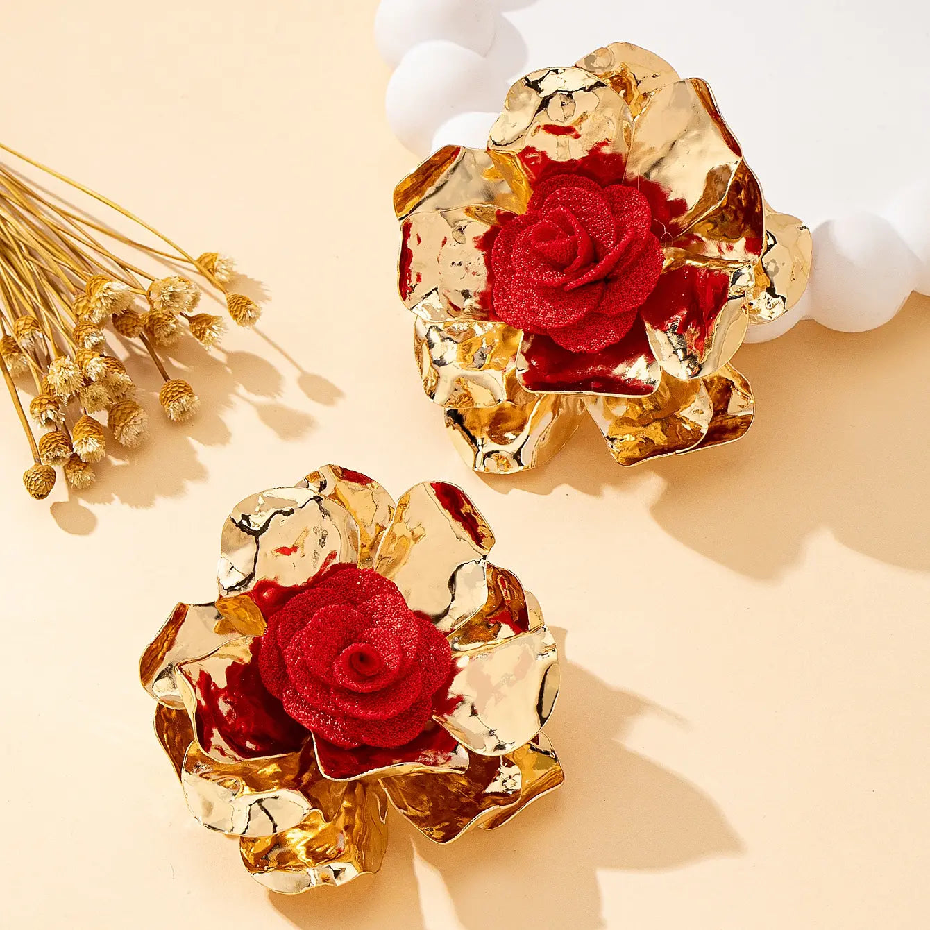 gold-toned textured flower-shaped hair clips featuring vibrant red fabric roses at their center, part of the red floral jewelry set gold rose necklace and earrings.