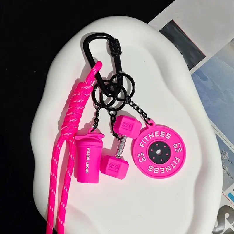 Porte-clés de musculation en silicone rose vif comprenant des miniatures d’haltères en corde torsadée et des breloques de disque de poids, pour un usage en cadeau salle de sport ou shaker.