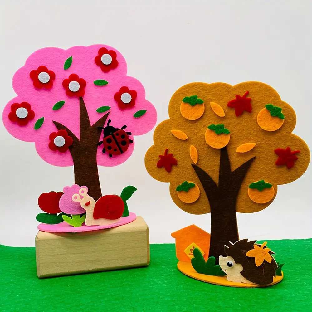 kit de manualidades estacionales de árbol de fieltro tipo diy que incluye un árbol de fieltro rosa con flores rojas y una mariquita, junto con un árbol de fieltro naranja decorado con naranjas y hojas de otoño.
