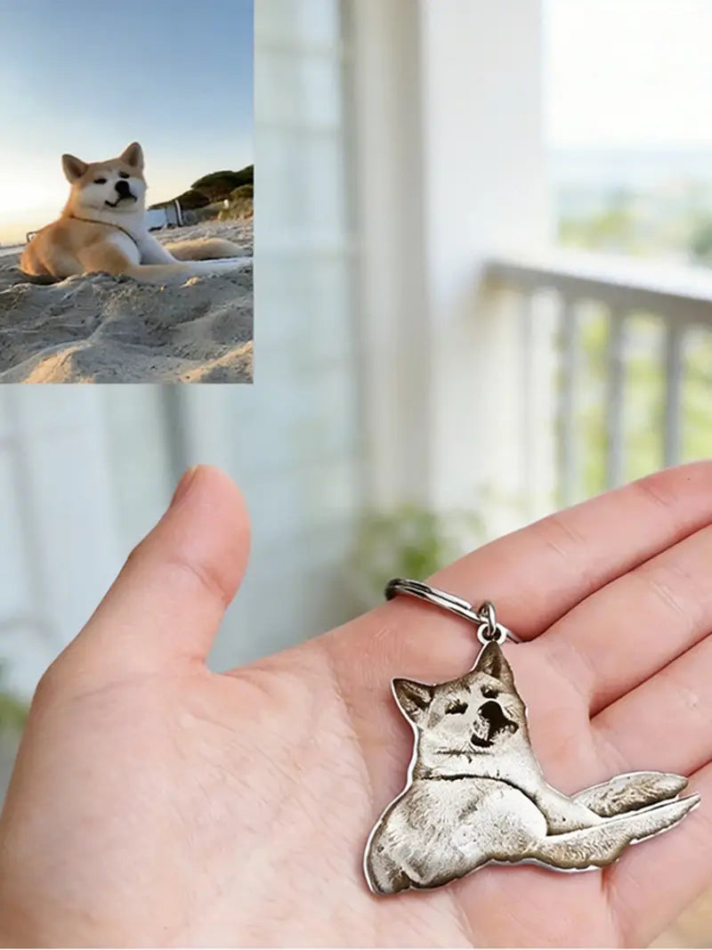 silver-colored finely detailed stainless steel custom photo engraved keychain pendant shaped like a reclining akita dog