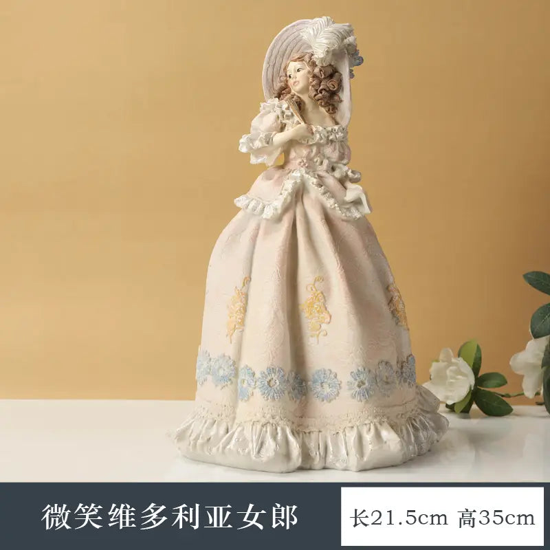 A delicate porcelain figurine of a smiling Victorian-era lady in an ornate off-white gown with floral embroidery and lace trim from a Victorian couple resin figurine home decor set.