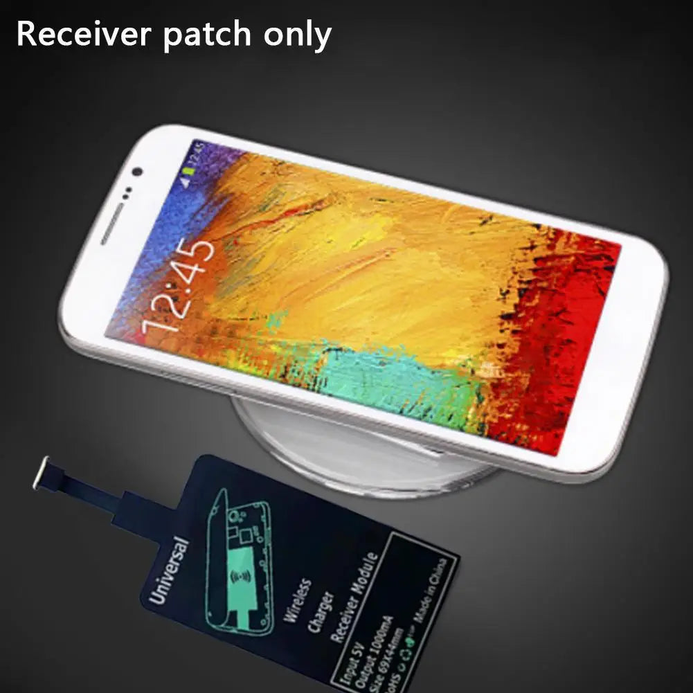 Ein weißes Smartphone mit farbenfrohem abstraktem Hintergrundbild, das auf dem Display angezeigt wird und auf einem transparenten kabellosen Ladepad mit einem kabellosen Ladeempfänger für Android-Typ-C liegt.