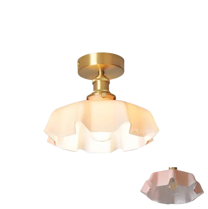 Un luminaire suspendu de style vintage à jupe florale en verre avec une base en métal à finition laiton et une tête de lampe en cuivre, présentant un abat-jour en verre blanc cassé en forme de pétales, vu depuis le dessous.
