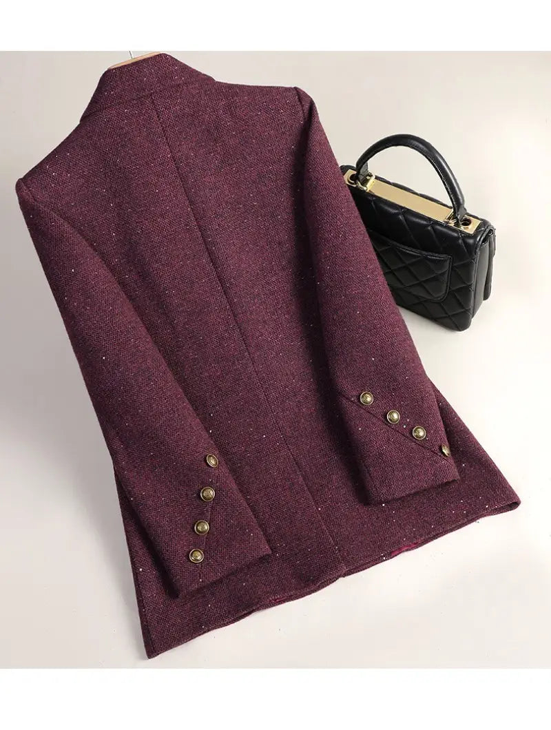 Wool blend double breasted blazer in textured maroon with subtle glitter accents and gold toned buttons on the cuffs.