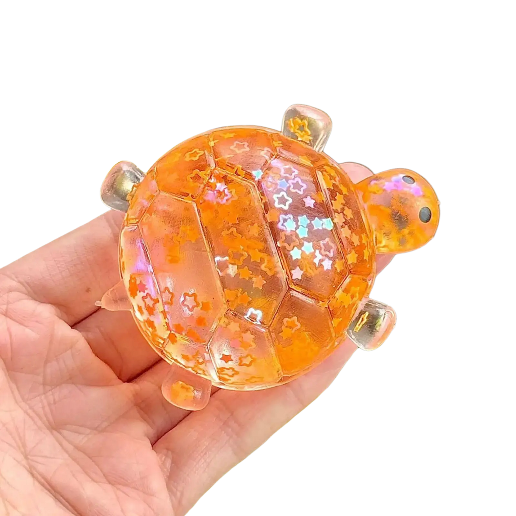 Translucent orange resin glitter turtle squeeze toy with star-shaped glitter and clear plastic limbs sensory fidget