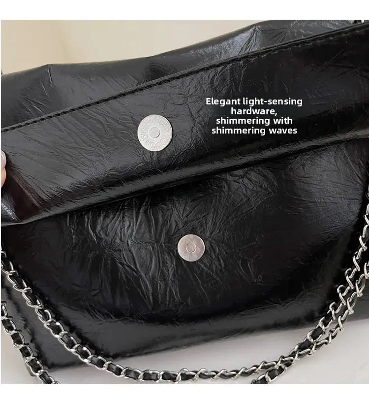 Bolso bandolera negro de piel sintética (PU) con correa de cadena, con herrajes circulares de tono plateado que brillan y ofrecen gran capacidad para un uso versátil entre los bolsos bandolera