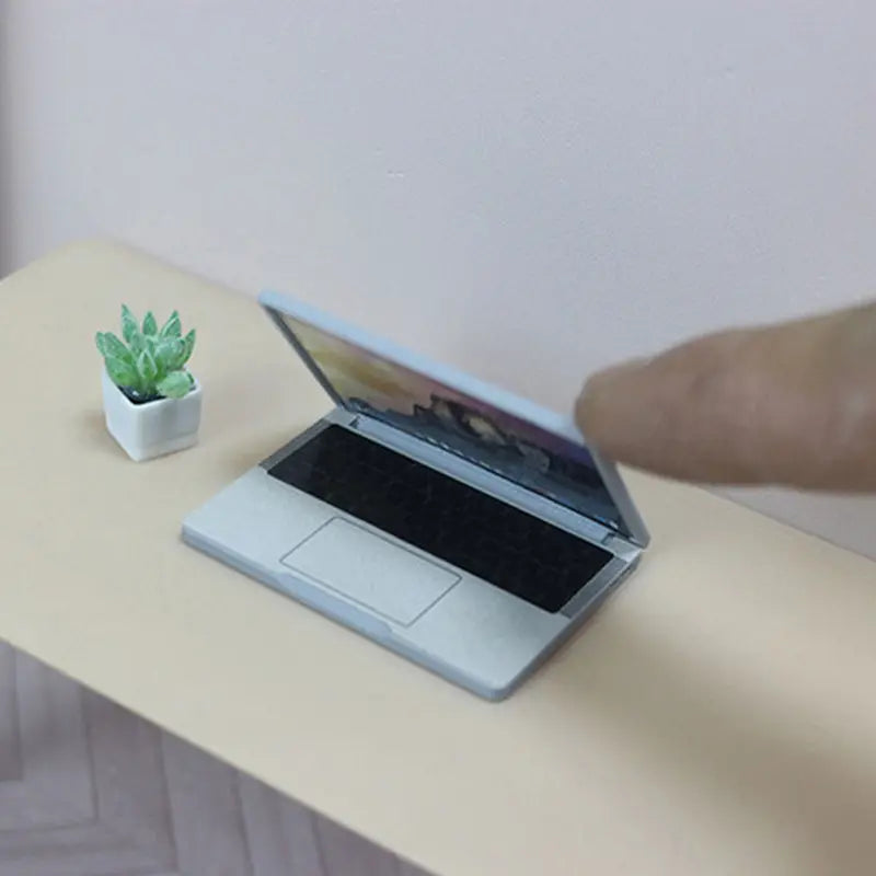 silver mini laptop with sleek minimalist design and black screen made of alloy for doll house accessory use