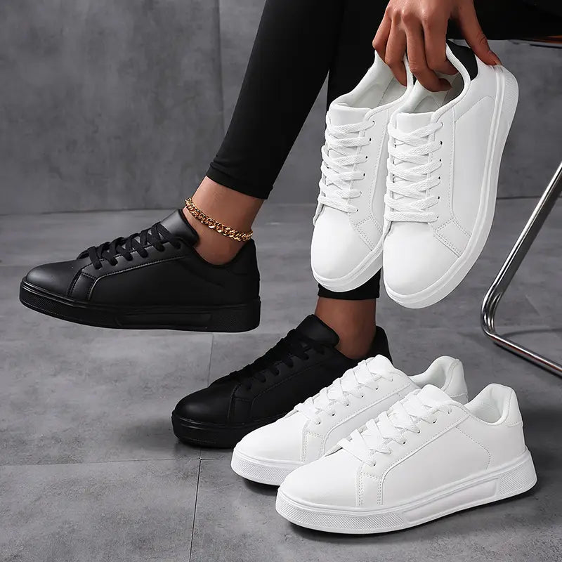 Weiße und schwarze Low-Top-Sneaker im Freizeitstil aus Leder, mit einem klaren minimalistischen Design und robusten Sohlen für sportliche Leichtgewichtsanwendungen.