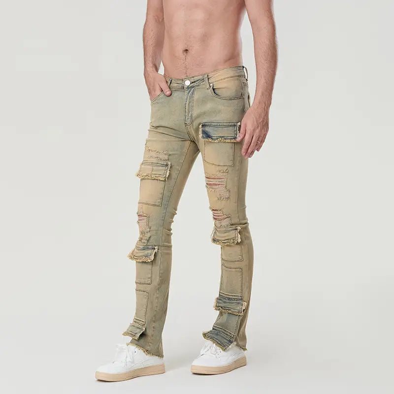 Une paire de jeans en denim délavé olive, coupe slim, avec plusieurs zones déchirées et effilochées, ainsi que des patchs renforcés aux poches cargo, conçue pour des hommes en jeans empilés déchirés, coupe slim, style streetwear.