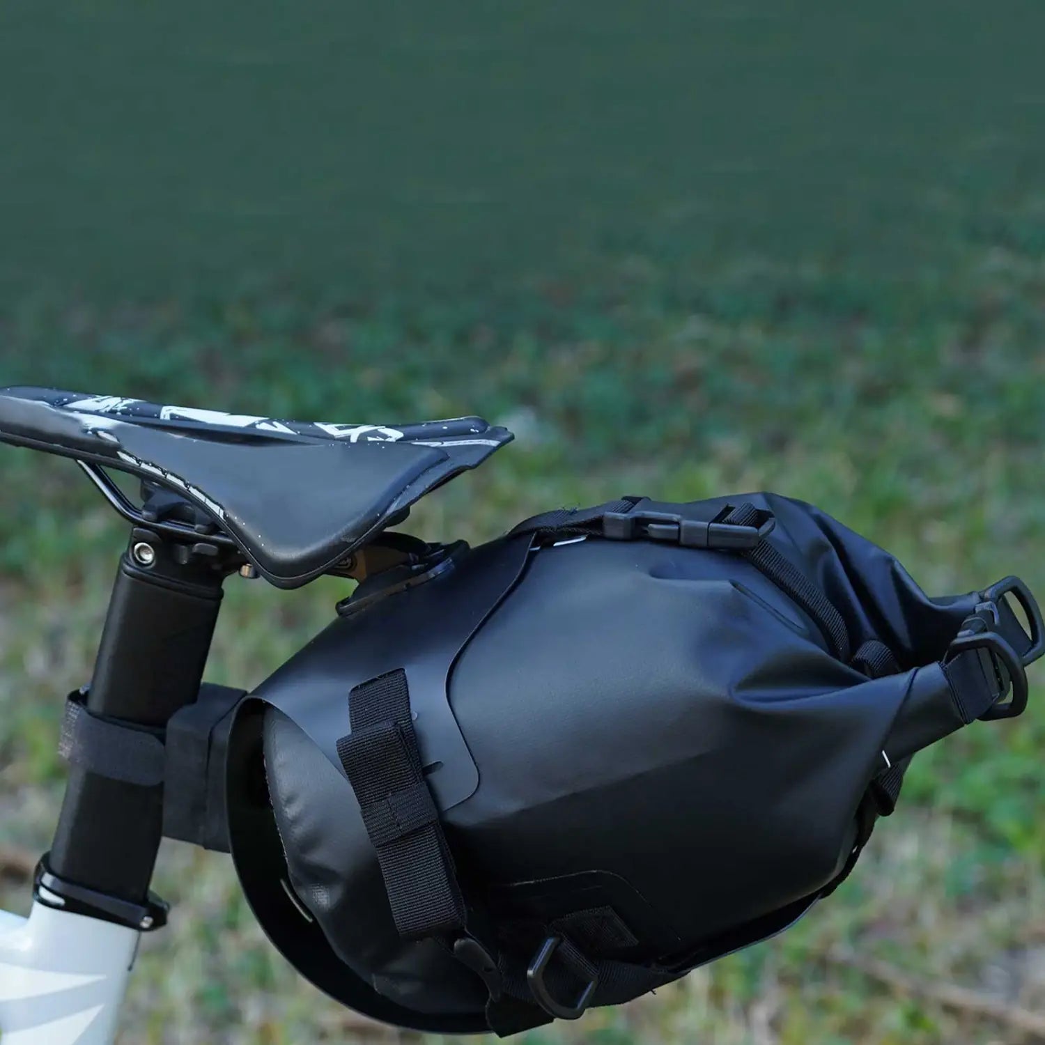 black waterproof bike saddle bag stabilizer bracket carrier with adjustable straps and secure closure system shown from the back side