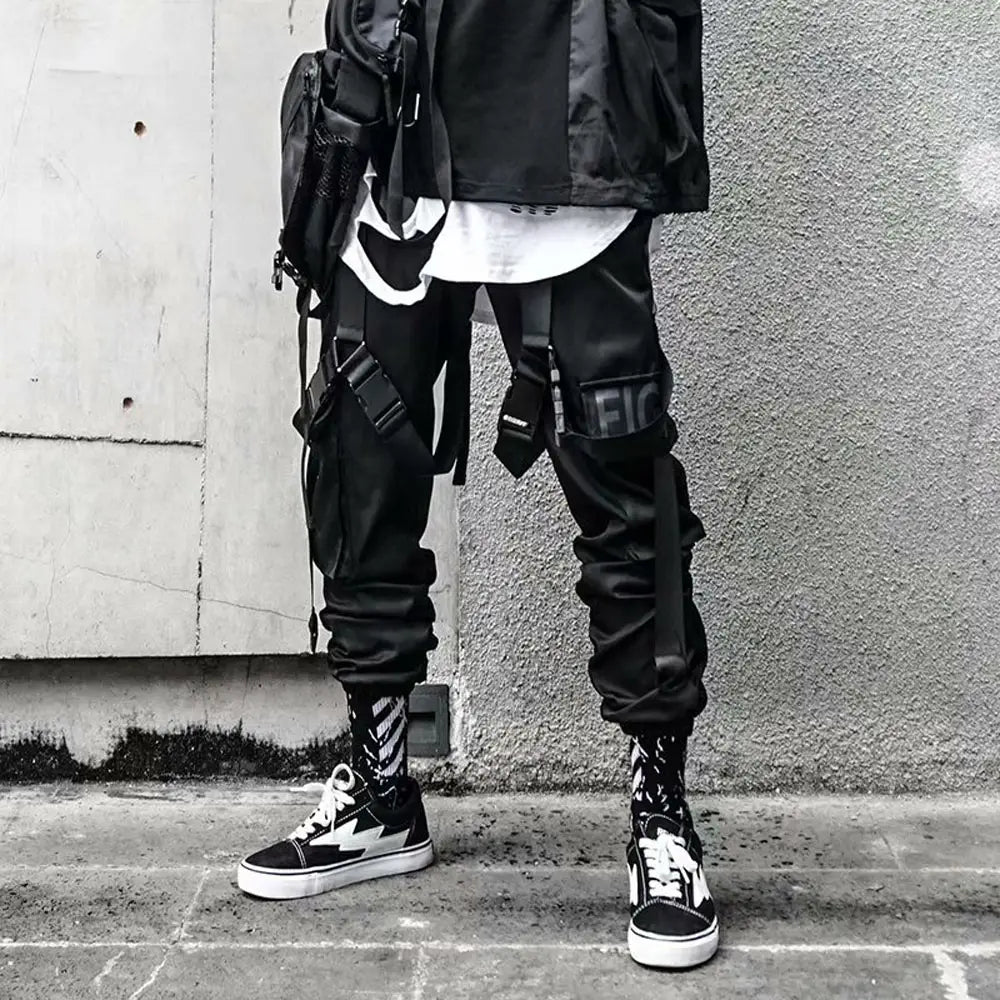 Pantalon cargo joggers streetwear pour hommes en noir, design tactique, avec plusieurs poches et bretelles réglables pour un usage urbain fonctionnel.