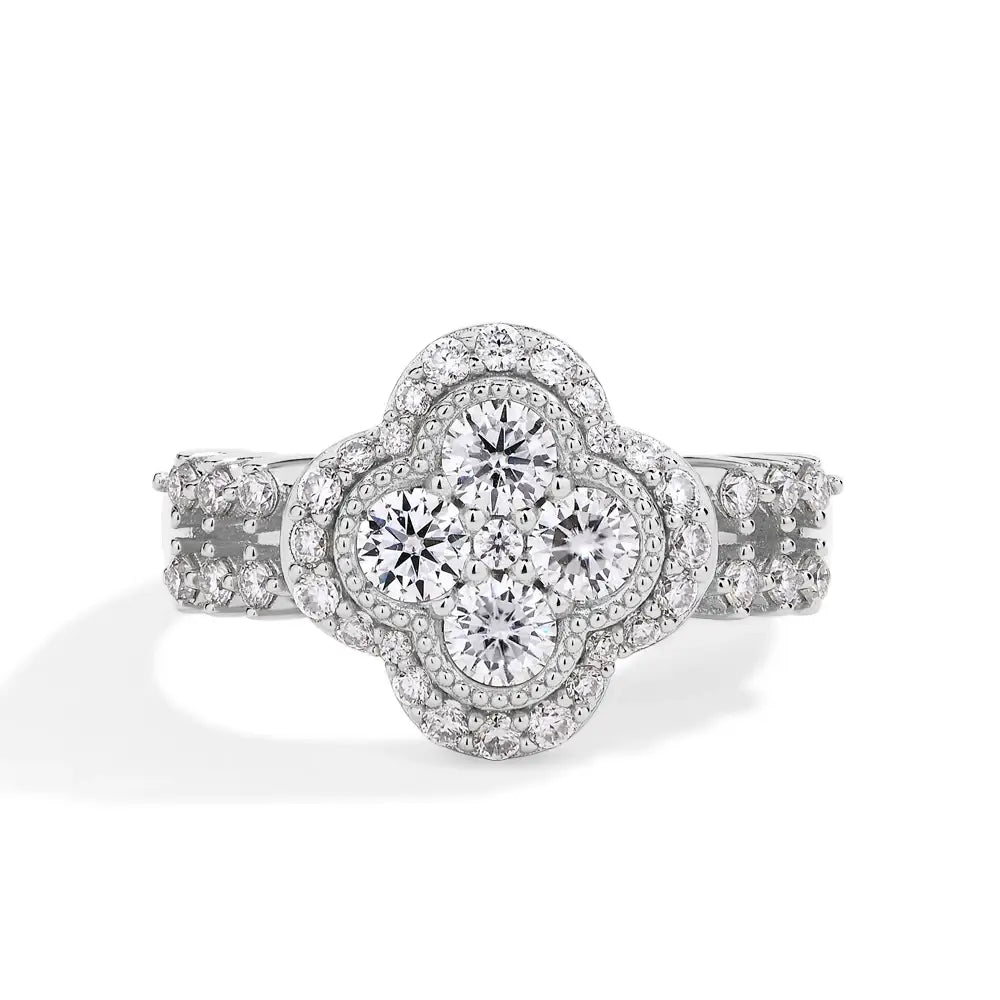 Anillo de diamante de trébol de cuatro hojas de plata en metal blanco con un grupo central de diamantes talla redonda rodeado de piedras más pequeñas engastadas en pavé.