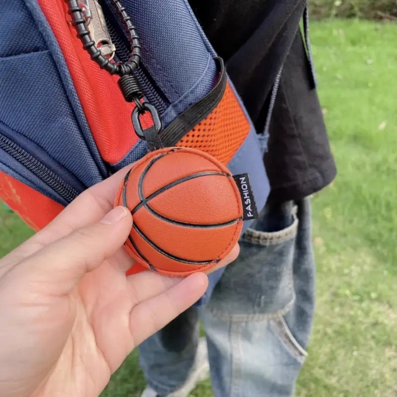 Leather sports ball keychain set bag charm featuring an orange basketball-shaped keychain with black stitched lines and a small fashion tag.