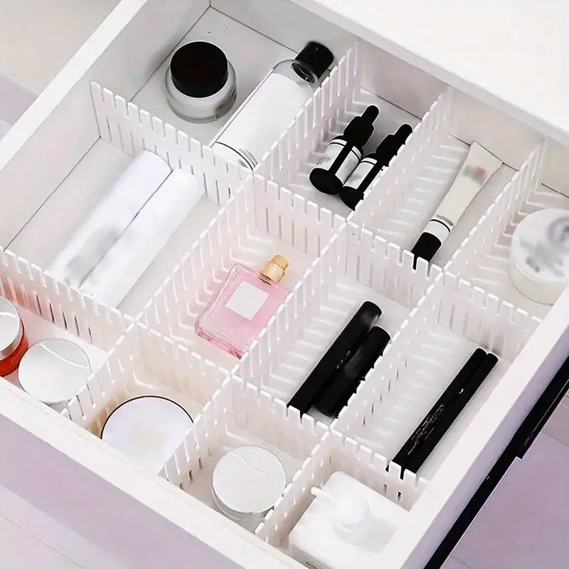 adjustable white plastic drawer divider partition with segmented compartments holding various beauty products for organized storage