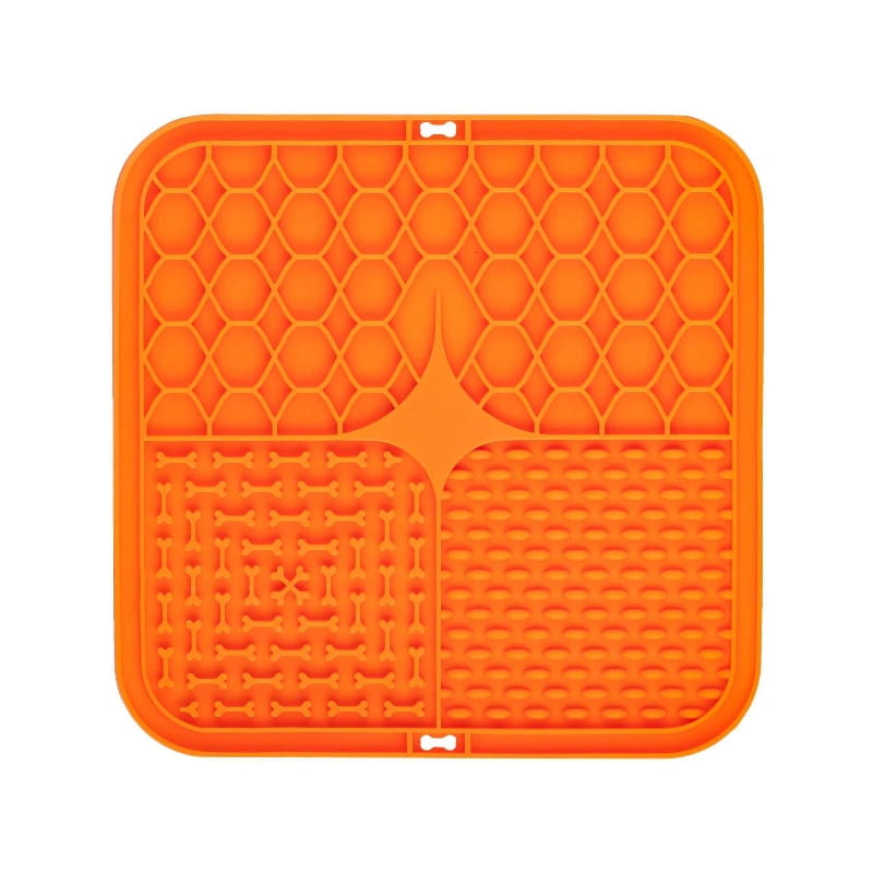 Bright orange silicone slow feeder pet lick silicone mat with honeycomb pattern and bone-shaped cutouts for controlled mealtime.