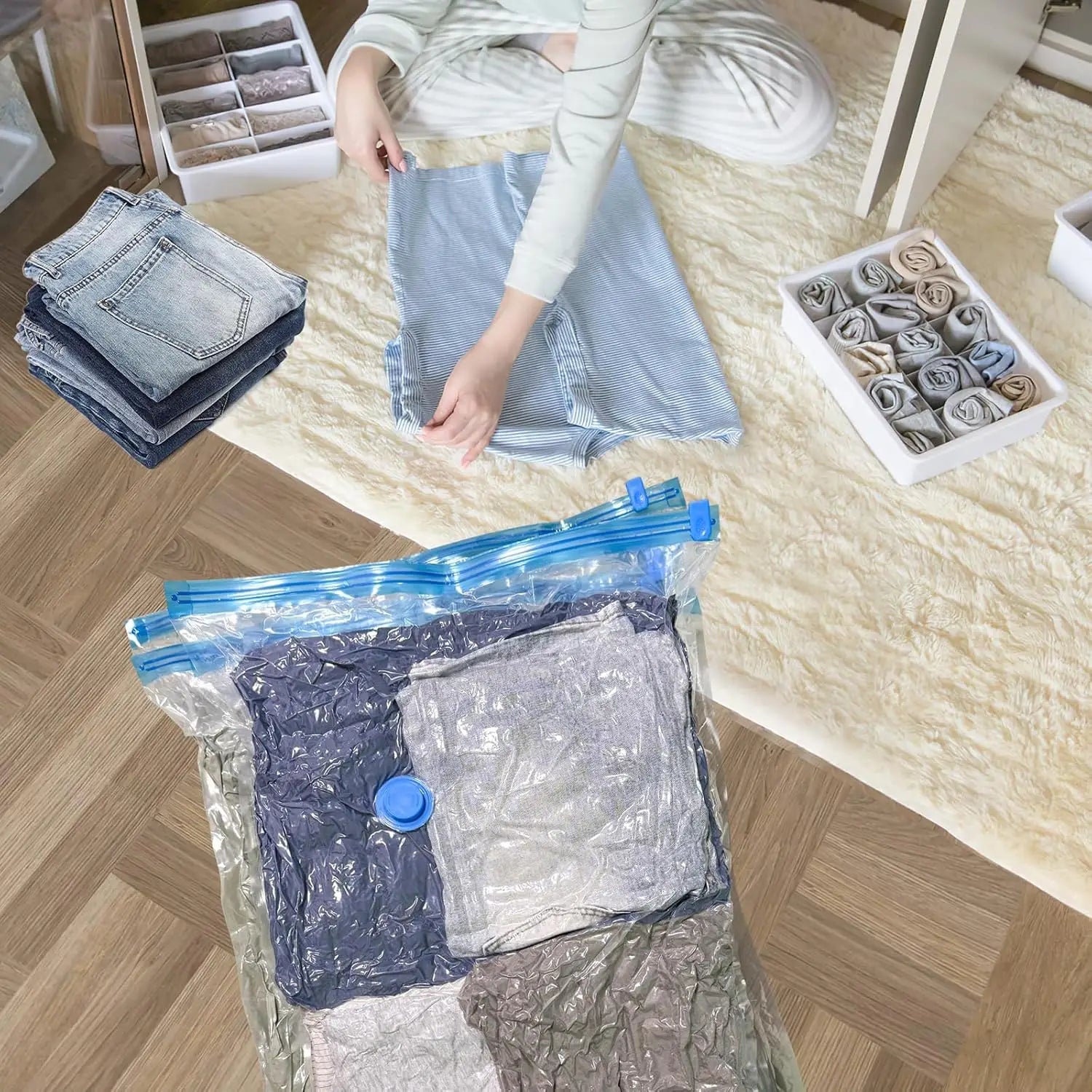 klare Kunststoff-Vakuum-Aufbewahrungsbeutel für Kleidung und Decken mit blauen Reißverschluss-Verschlüssen und blauen Pumpknöpfen, die gefaltete Kleidungsstücke enthalten.