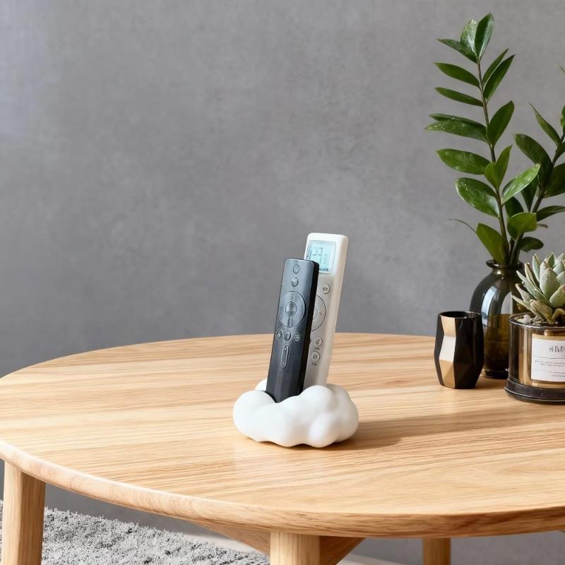 White ceramic cloud-shaped remote control holder designed as a desktop organizer stand for remote control storage.