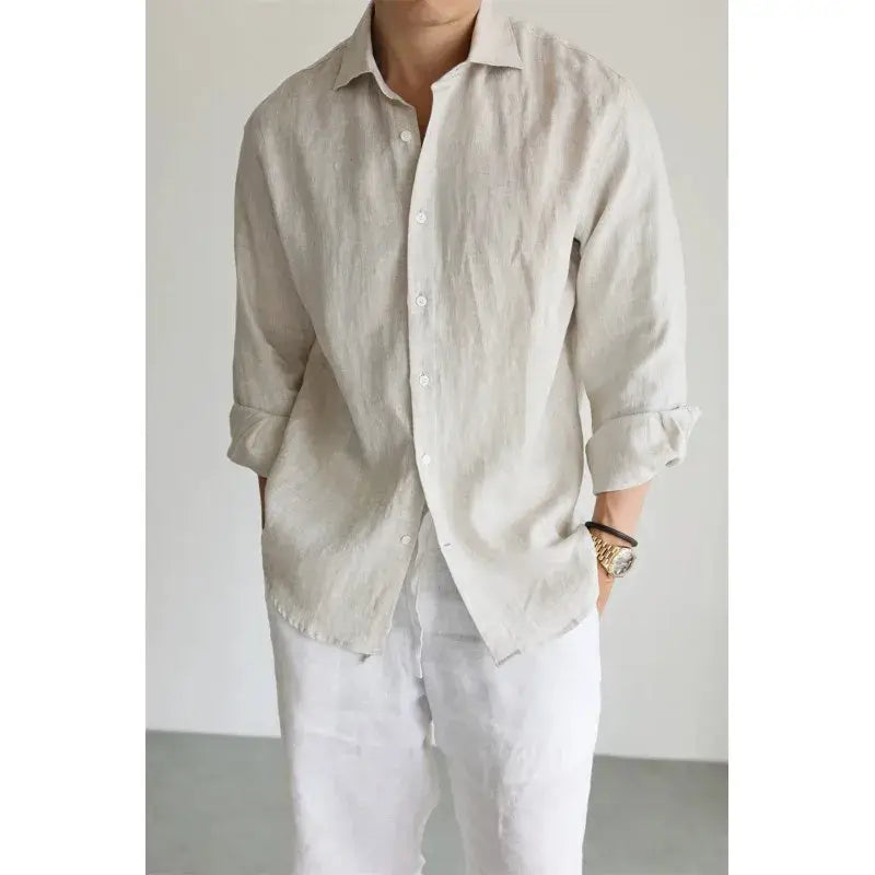 A light beige men cotton linen casual button down shirt with long sleeves and rolled cuffs.