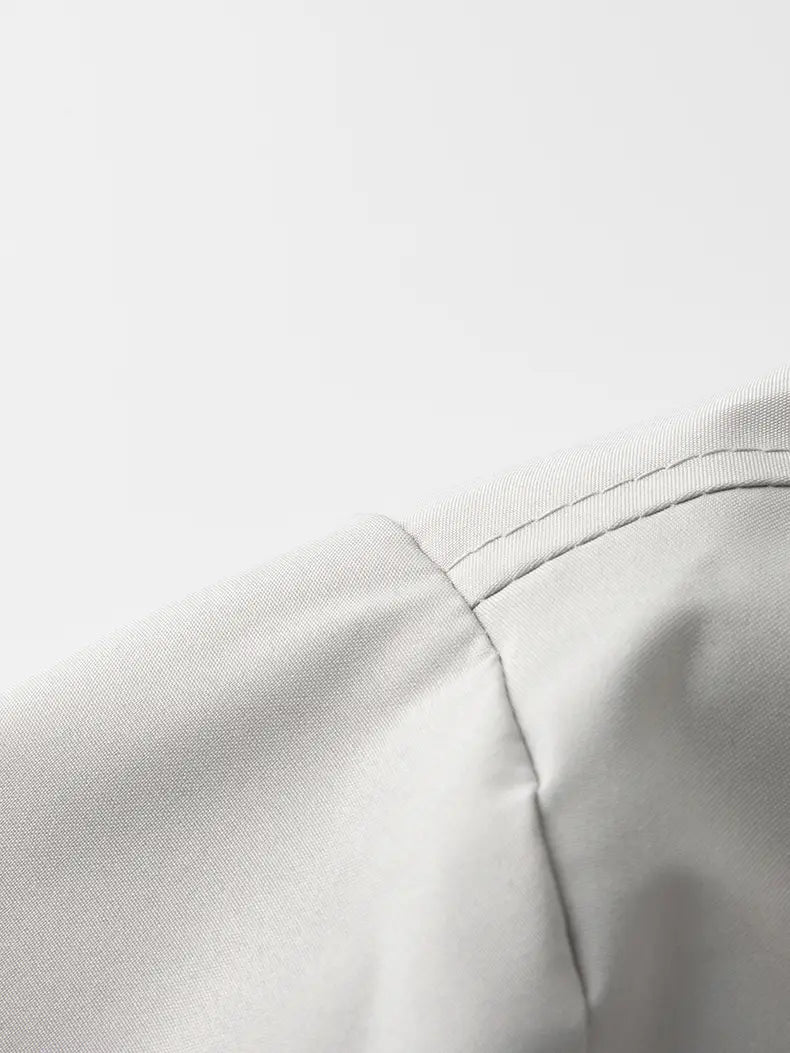 light gray finely woven fabric with neat stitching along the shoulder seam of a waterproof hiking jacket men windbreaker ideal for autumn hiking.