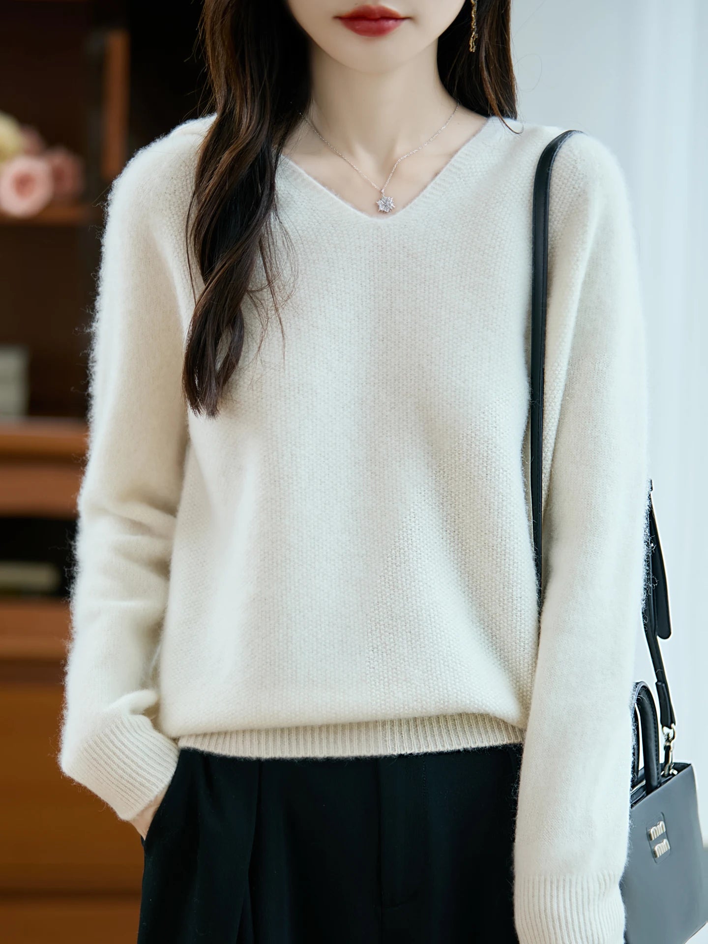 Cream-colored pure wool hooded pullover sweater with soft-knit v-neck and ribbed cuffs and hem.