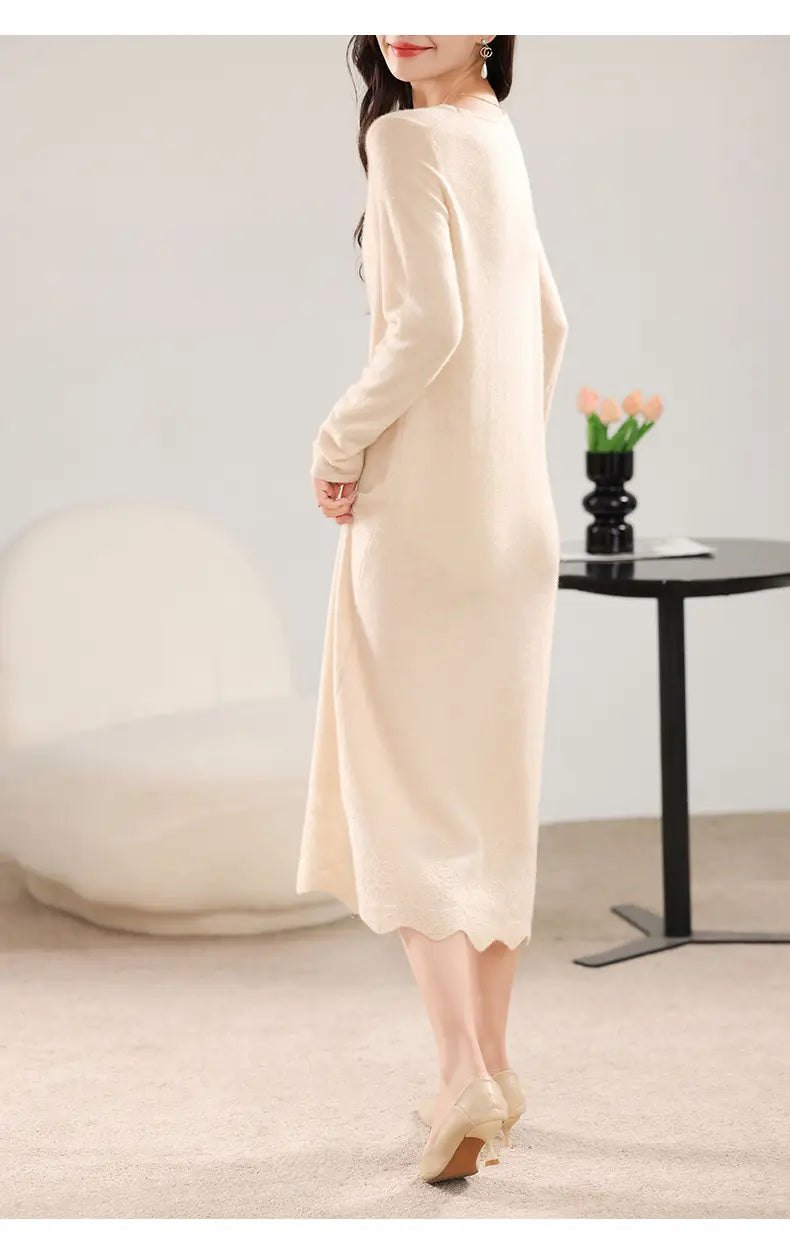 Ein weiches Wollstrickkleid in Creme mit langen Ärmeln und gesäumtem Volantabschluss.