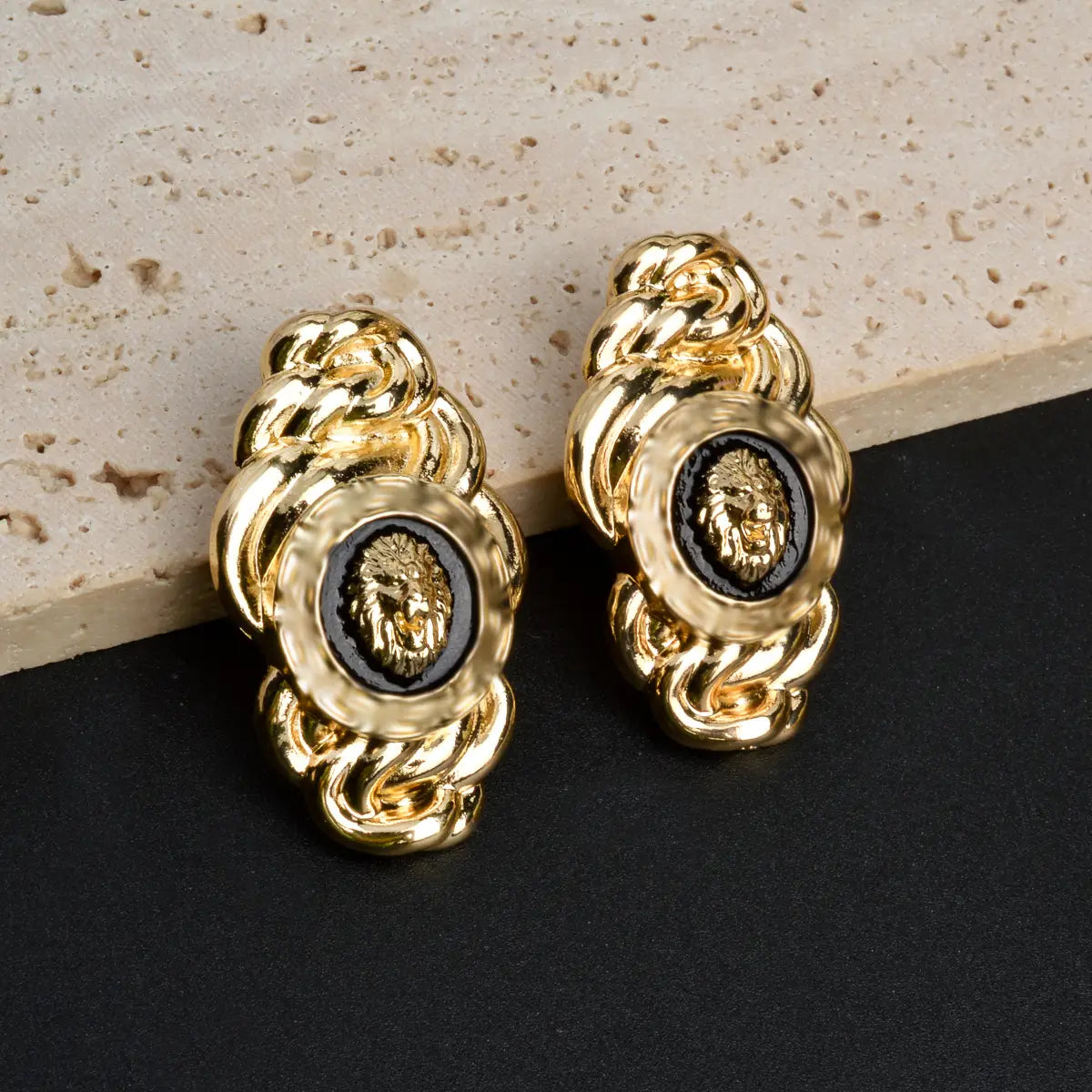 Aretes tipo tachón con cabeza de león en tono dorado, con un detallado intrincado de eslabones en cadena y aplicación negra, del juego de joyería de león de oro de Dubái de 18 quilates.