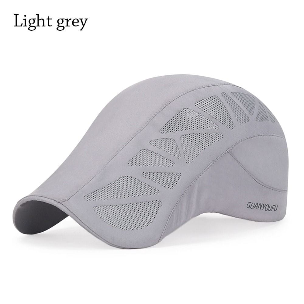 Gorra estilo bombín de malla para golf gris claro, con paneles de ventilación transpirables y un logotipo de marca sutil en el lateral, diseñada para conducir en verano.