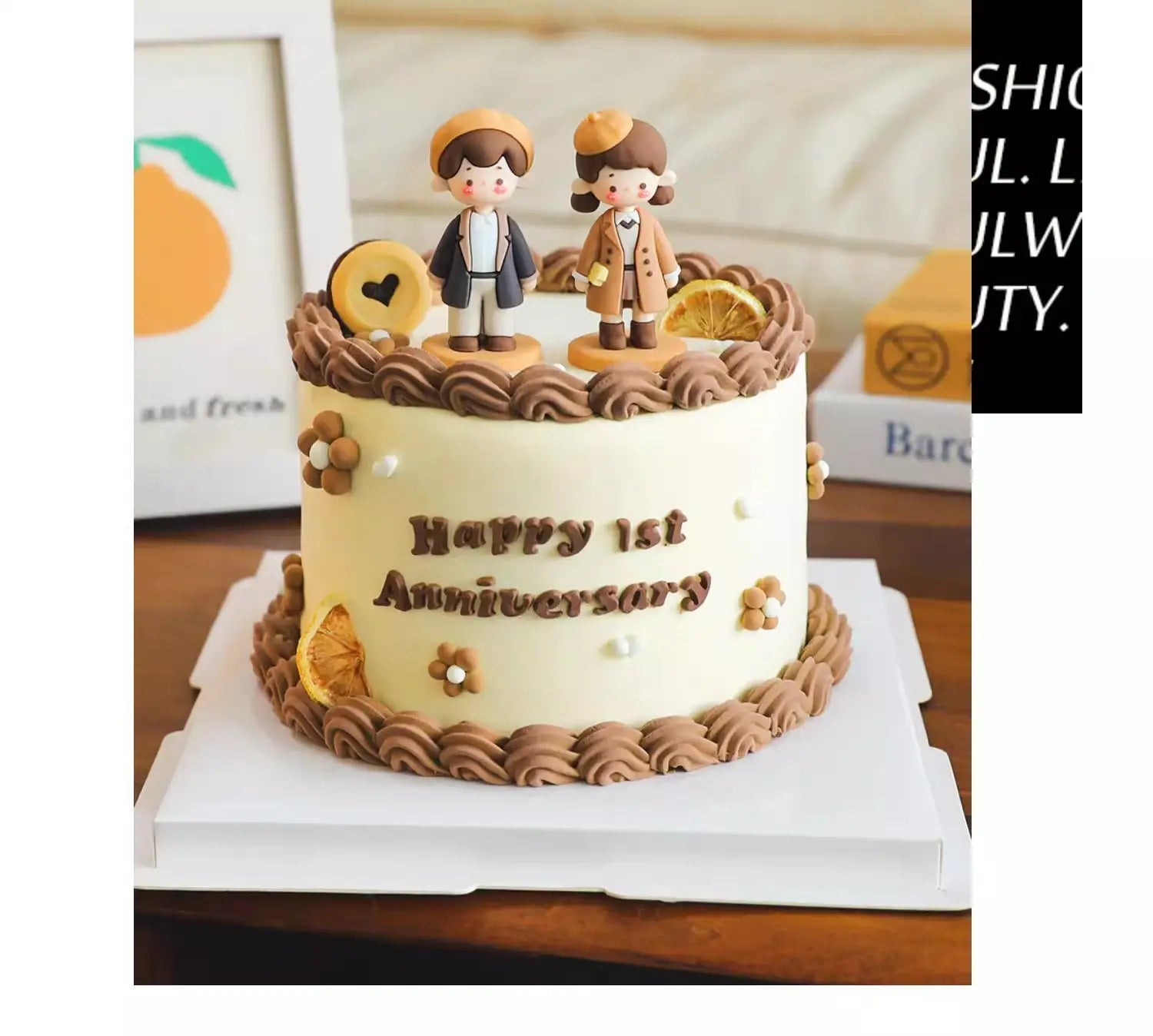 Un charmant gâteau d’anniversaire de couleur crème décoré de tourbillons de glaçage au chocolat, de rondelles d’orange séchées, de fleurs délicates, et surmonté d’un sujet de gâteau pour couple en PVC représentant un couple, habillé de manteaux bruns assortis, pour la décoration d’anniversaire de la Saint-Valentin.