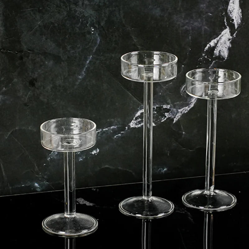 Juego de tres portavelas de pilar de vidrio transparente, con tallos esbeltos y bases circulares, para una decoración moderna de mesa.