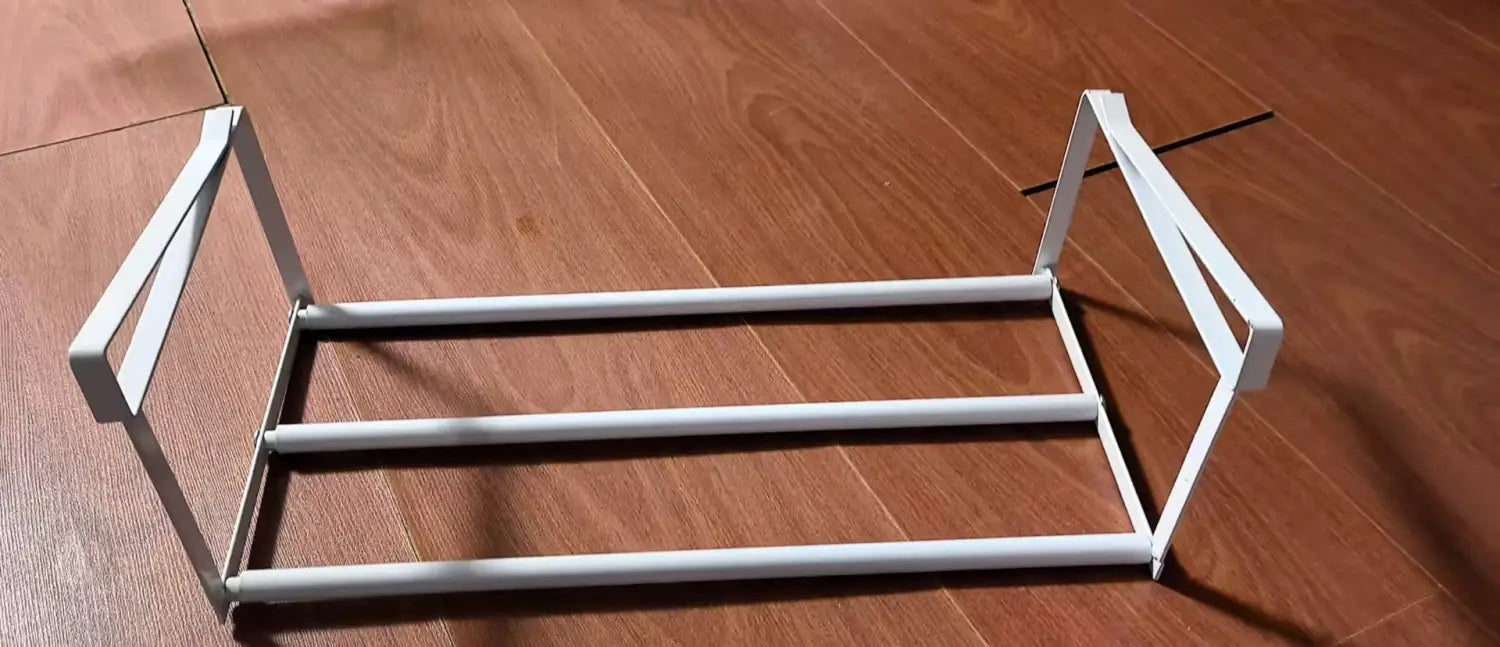 White metal telescopic shoe rack with three horizontal bars and rectangular side frames for effective shoe storage and organization.