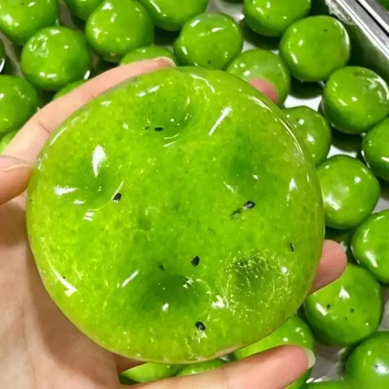 Jouet à mâcher et à malaxer en forme de fromage, vert vif et brillant, conçu pour soulager le stress, texture souple et molle, avec de petites taches noires ressemblant à une pastèque, pour un soulagement efficace du stress lié au jouet