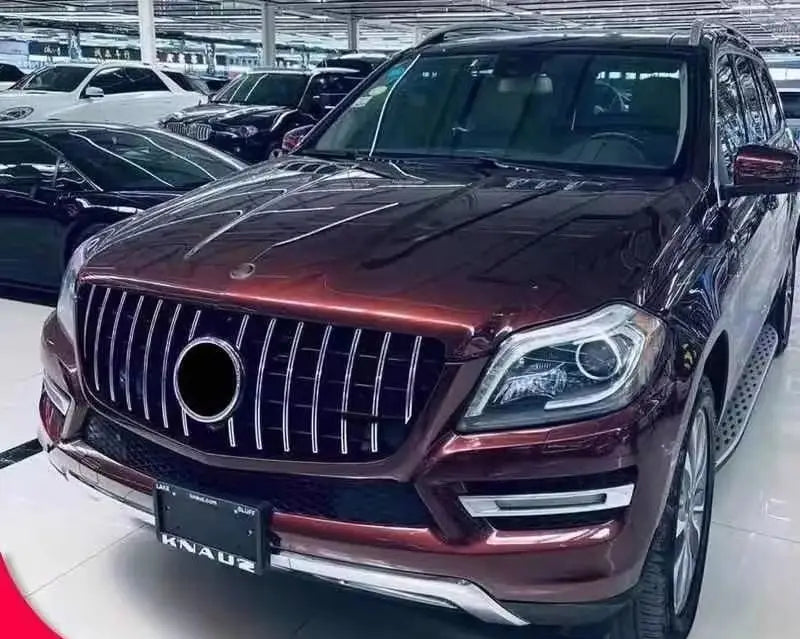 A glossy burgundy Mercedes-Benz GL-Class SUV featuring a GTR front grille with a prominent chrome finish and sleek LED headlights for Mercedes Benz X166 2013 2015 models.