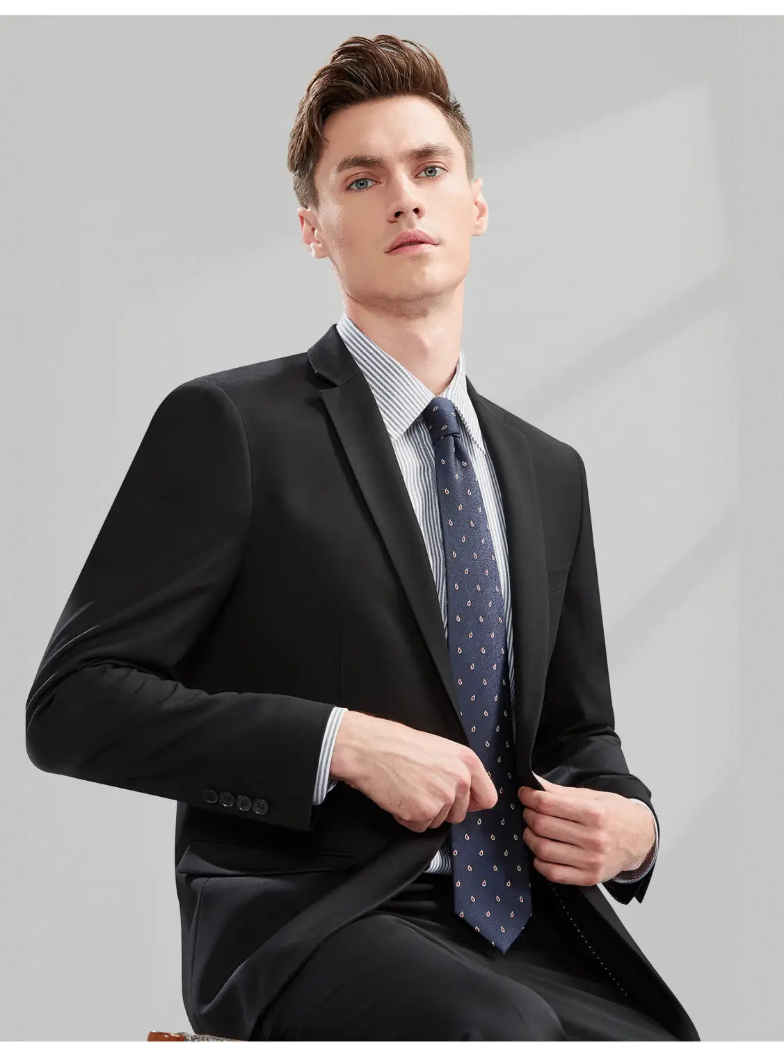 Veste de costume noire pour homme en coupe slim, parfaitement taillée, avec revers à encoches et poignets boutonnés, avec un type de fermeture boutonnée simple pour une tenue formelle et professionnelle décontractée.
