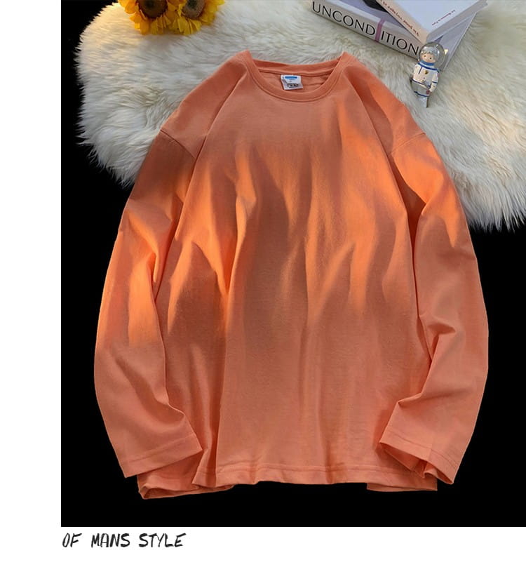 A soft peach-colored oversized long sleeve blank t-shirt with a relaxed fit and crewneck design.