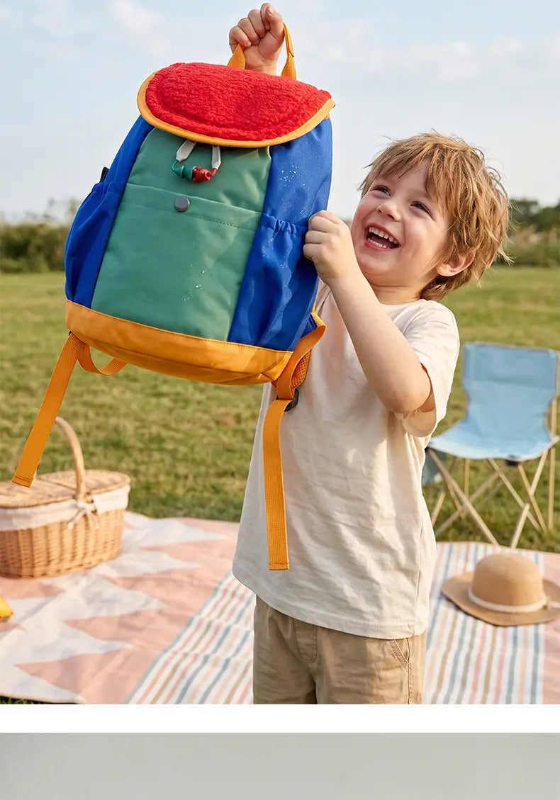 Ein lebhaftes mehrfarbiges leichter Fuzzy-Rucksack für Kinder mit plüschigem rotem Oberteil und gelber Verzierung, entworfen für die Verwendung als Kindergartentagesrucksack.