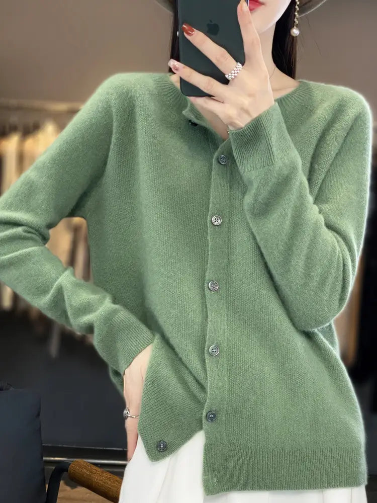 A soft sage green merino wool cardigan for women featuring a classic button front design and ribbed cuffs.